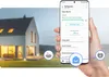 A hand holding a smartphone displaying a refrigerator app, with a house in the background. Náhled obrázku produktu