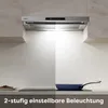 A kitchen scene showing a range hood installed above a stovetop with a pan on it. The image is split to show two lighting levels. Náhľad obrázku produktu