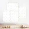 Four white climbing wall panels with grey dots are mounted on a white wall above a wooden floor. Two wooden dumbbells and a textured ball are on the floor. Náhled obrázku produktu