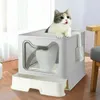 A cat is sitting on top of a gray litter box with a white tray. Náhled obrázku produktu