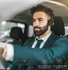 A man wearing a suit and a headset is driving a car. Produktbild-Vorschau