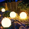 Outdoor garden scene at night with illuminated spherical lights. Produktbild-Vorschau