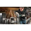 A man is using an angle grinder to cut metal in a workshop. Produktbild-Vorschau