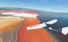 An ICON A5 aircraft flying over colorful salt flats and a body of water. Anteprima dell’immagine prodotto