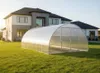 A greenhouse in front of a modern house on a sunny day. Produktbild-Vorschau