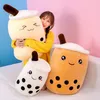 A woman is holding a large plush toy shaped like a bubble tea cup, with two other plush bubble tea toys in front of her. Produktbild-Vorschau
