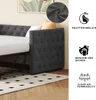 A close-up view of a gray upholstered daybed with a white mattress, set against a light-colored wall and a patterned rug on a wooden floor. Informational icons and text are displayed on the right side of the image. Produktbild-Vorschau