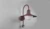 A brown outdoor wall light with a white globe is mounted on a light gray wall. Produktbild-Vorschau