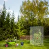 A garden scene with gardening tools, plants, and a greenhouse. Náhled obrázku produktu