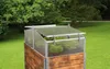 A cold frame greenhouse sits on a raised wooden planter in a garden setting. Voir les images du produit