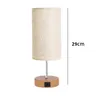 A bedside lamp with a fabric shade and a wooden base with USB ports. Produktbild-Vorschau