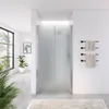 A modern bathroom with a frosted glass shower enclosure, a towel rack with towels, and a large window with plants. Náhled obrázku produktu
