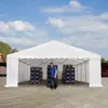A man stands inside a large white tent, with stacks of blue crates on pallets on either side. Produktbild-Vorschau