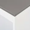 A close-up view of the corner of a white table with a gray top. Náhled obrázku produktu