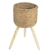 A woven basket planter with a tripod stand. Produktbild-Vorschau