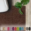 A shaggy rug in a living room setting, next to a white sofa and a Monstera plant. A row of color swatches is displayed at the bottom. Náhled obrázku produktu