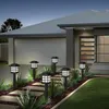 Solar garden lights illuminating a pathway in front of a modern house at dusk. Anteprima dell’immagine prodotto