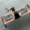 A woman sits on a park bench with cushions, using a tablet. Náhled obrázku produktu