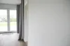 Interior view of a room with large glass doors leading to a garden, and grey curtains. Anteprima dell’immagine prodotto