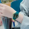 A person wearing a watch and holding a drink. Produktbild-Vorschau