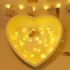 A heart-shaped frame filled with fairy lights, with small photos inside. Produktbild-Vorschau