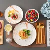 A table setting with plates of food, a bowl of berries, and cutlery. Náhled obrázku produktu