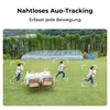 Children running in a grassy yard with a table and chairs set up. Produktbild-Vorschau