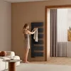 A woman is hanging a towel on a black towel warmer in a modern bathroom. Anteprima dell’immagine prodotto
