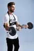 A man is performing bicep curls with a barbell while wearing an arm blaster. Náhľad obrázku produktu