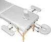 A white massage table with accessories shown separately, indicating assembly or optional parts. Náhled obrázku produktu