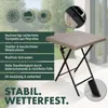 A square folding table with a rattan-like top and black metal legs, shown outdoors on a tiled patio with a balcony in the background. Text overlays highlight product features. Produktbild-Vorschau