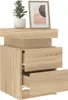 A wooden nightstand with two drawers, topped with a potted plant and a framed picture. Náhľad obrázku produktu