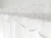 A close-up view of white sheer curtains hanging from a rod. Produktbild-Vorschau