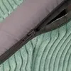 A close-up view of a zipper on a green corduroy pet bed. Podgląd zdjęcia produktu