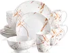 A collection of white ceramic dinnerware with a copper marble pattern, including plates, bowls, and mugs, arranged in a studio setting. Náhled obrázku produktu