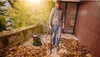 A man is using a wet/dry vacuum cleaner to clean up fallen leaves in an outdoor patio area. Voir les images du produit