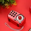 A red retro-style radio is placed on a red surface, with some green foliage in the background. Produktbild-Vorschau
