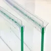 Close-up view of two transparent shower door seals attached to glass panels, with water droplets visible on the seals. Podgląd zdjęcia produktu