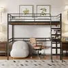 A loft bed with a desk and shelves underneath, set up in a bedroom with a chair and a small sofa. Produktbild-Vorschau