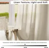 A close-up of a sheer linen curtain hanging by a window, with a chair visible on the left. Produktbild-Vorschau