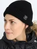 A woman wearing a black beanie and jacket. Produktbild-Vorschau
