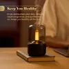Aroma diffuser with a warm light, placed on a book on a wooden table. Podgląd zdjęcia produktu
