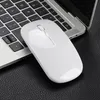 A white wireless mouse rests on a black textured surface next to a laptop keyboard. Produktbild-Vorschau
