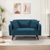 A blue corduroy sofa with two pillows is shown in a well-lit room with modern art on the wall. Anteprima dell’immagine prodotto