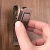 A hand is shown pressing a flush pull handle into a wooden surface. Produktbild-Vorschau