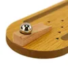 A close-up shot of a wooden bowling game with a metal ball on a wooden ramp. Produktbild-Vorschau