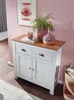 A white sideboard with a wooden top, decorated with two vases and a book, in a room with pink walls. Voir les images du produit