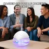 Four people are sitting on a couch, smiling and interacting. A humidifier is placed on a coffee table in the foreground. Produktbild-Vorschau