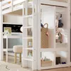 A white loft bed with a desk, wardrobe, and shelves, featuring children's items. Produktbild-Vorschau