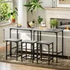 A bar table set with stools in a living room setting, next to a sofa and fireplace. Produktbild-Vorschau
